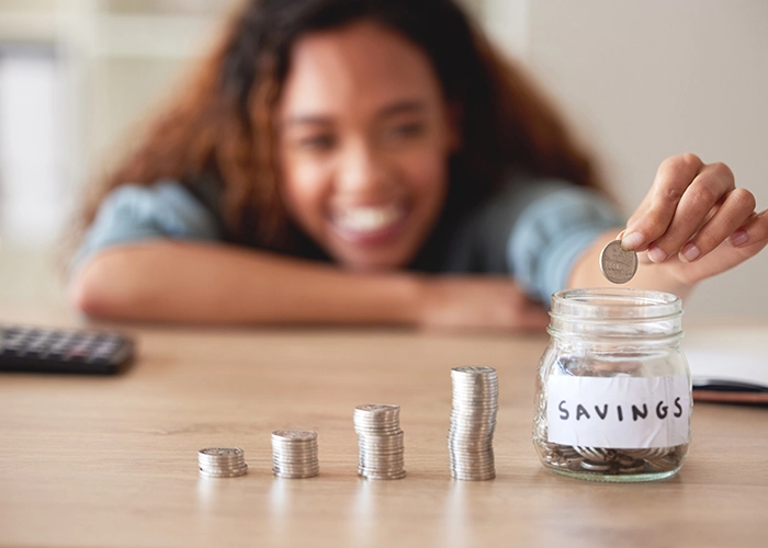 woman saving coins in a piggy bank