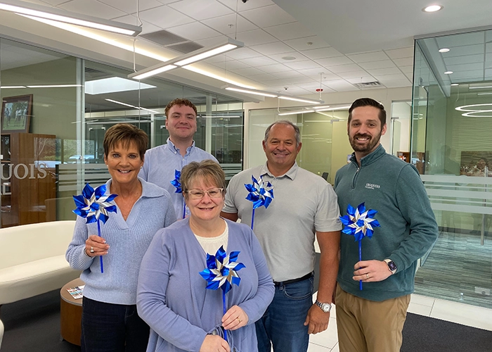 group photo of people wearing blue ribbons