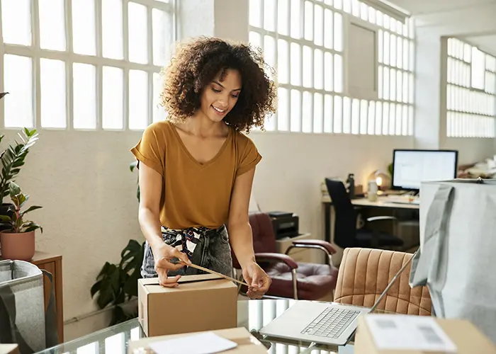 Business owner looking through documents near her laptop