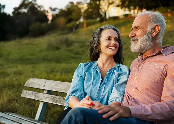 retired couple sitting on a bench