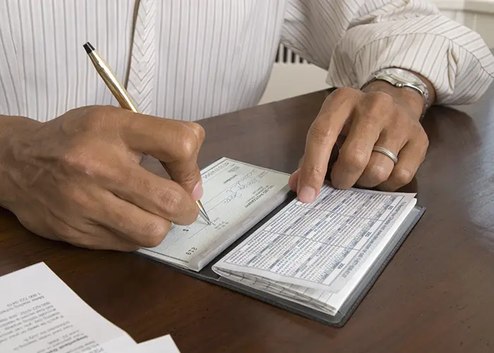 man writing out a check