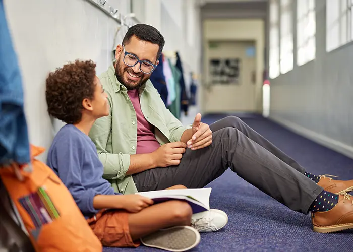 man sitting in hallway mentoring student